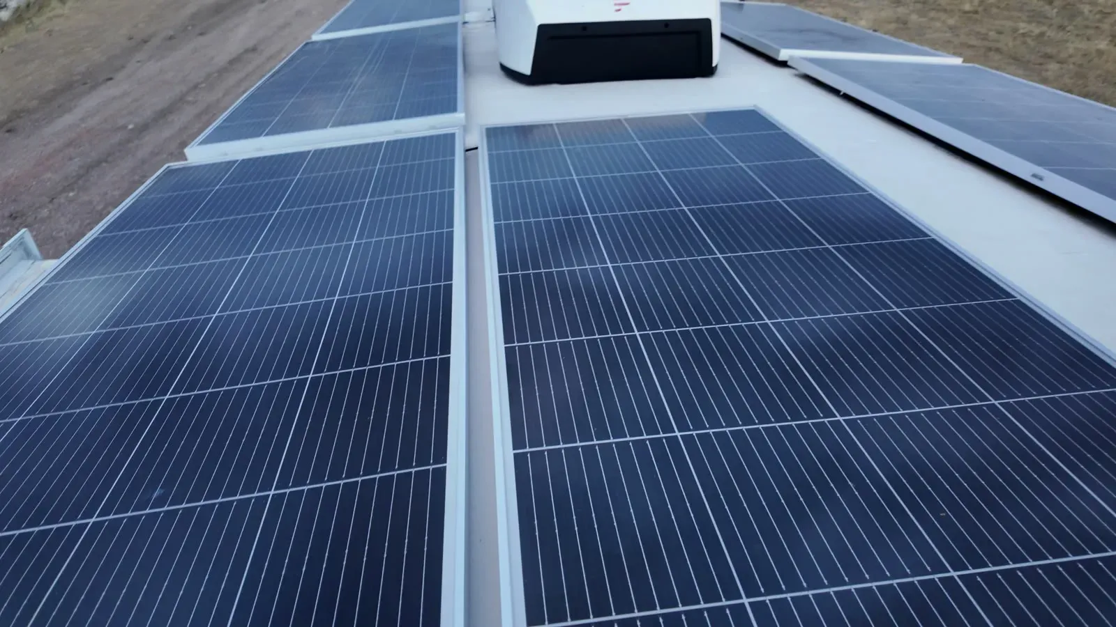 Solar panels covering the roof of the Brinkley fifth wheel, with a roof vent and air conditioner between them