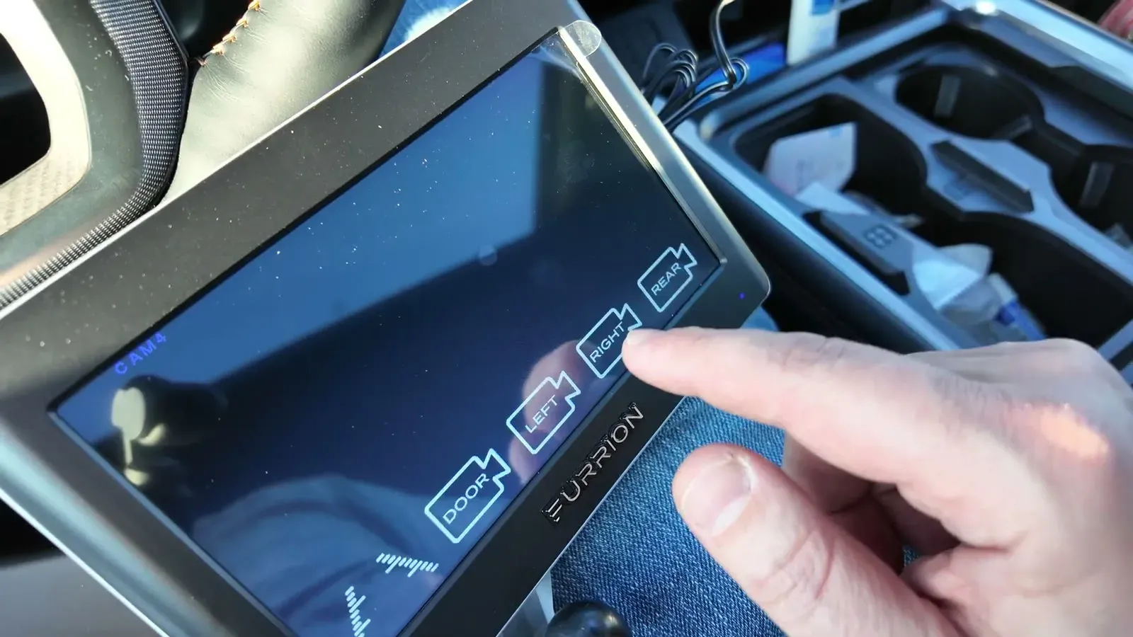 Tapping through the camera options on the Furrion Vision S monitor in the truck cab during setup.