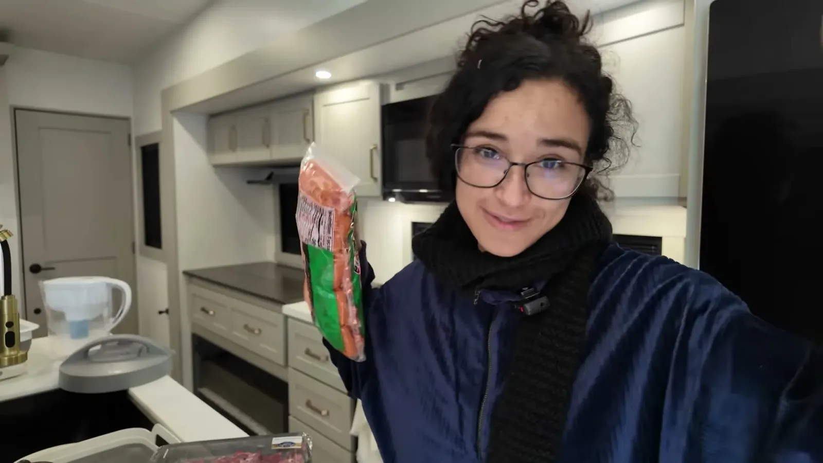 Fabiola holding up the family pack of pre-chopped stew meat in the RV kitchen before starting the Instant Pot