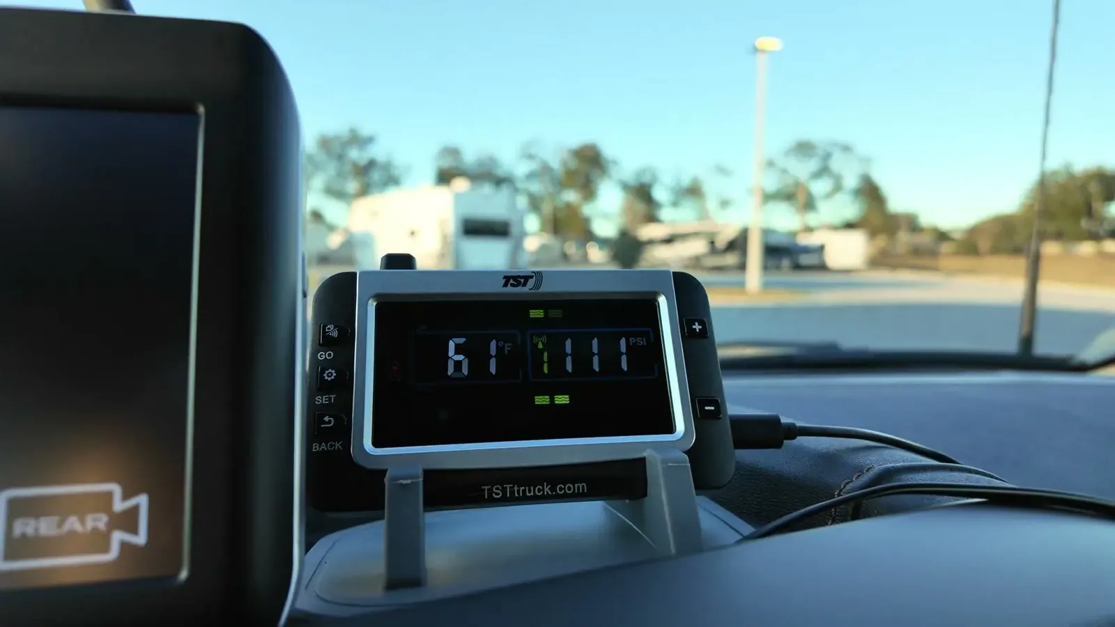 The TST tire pressure monitor on the dash showing its first temperature reading, with the RV lot blurred out the windshield.