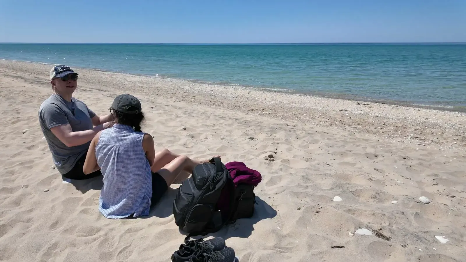 Sitting on the empty beach at the end of the dune hike, with Lake Michigan glowing turquoise behind us.